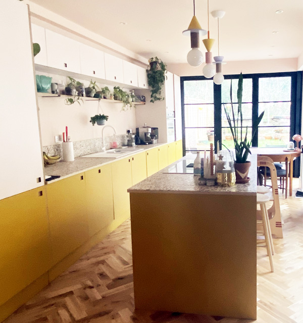 plywood faced kitchen with yellow laminate island and pale pink and yellow cupboards